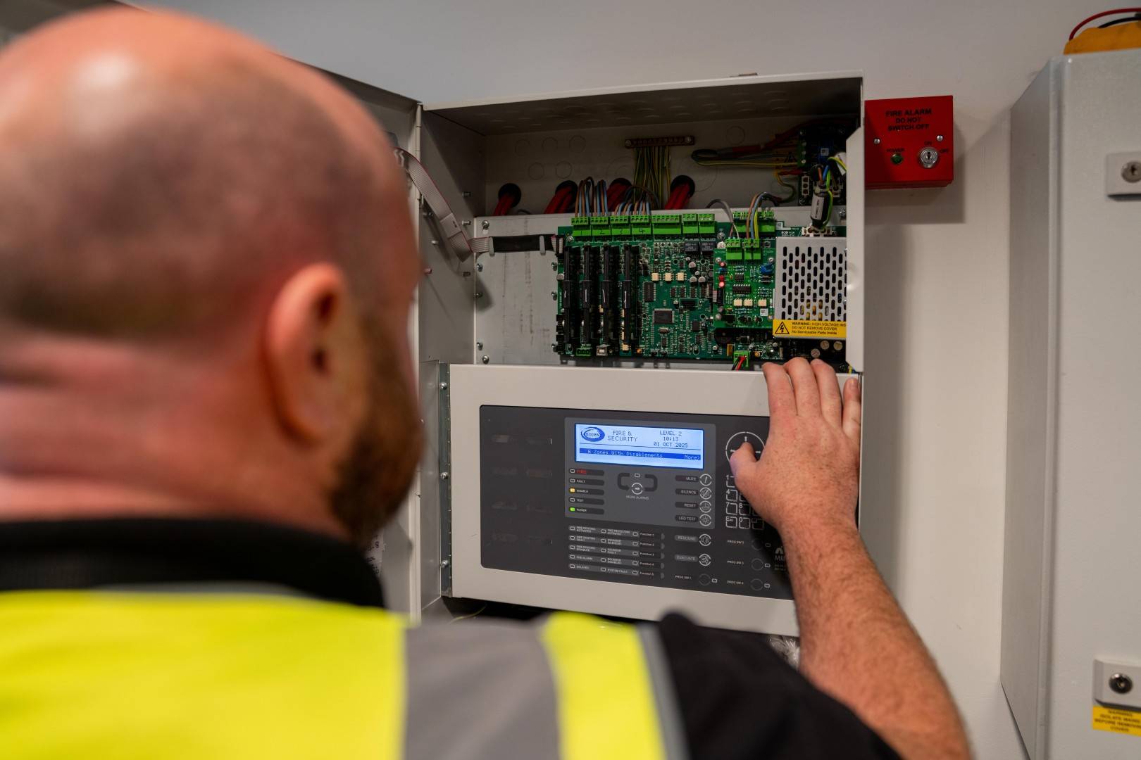 Engineer looking inside fire panel